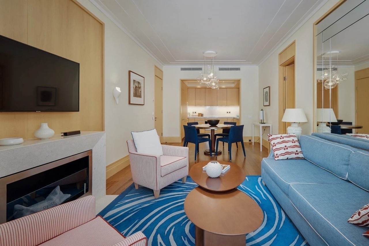 Living room with a fireplace and dining area in an apartment in Porto Montenegro, Tivat, Montenegro: modern interior and furniture.