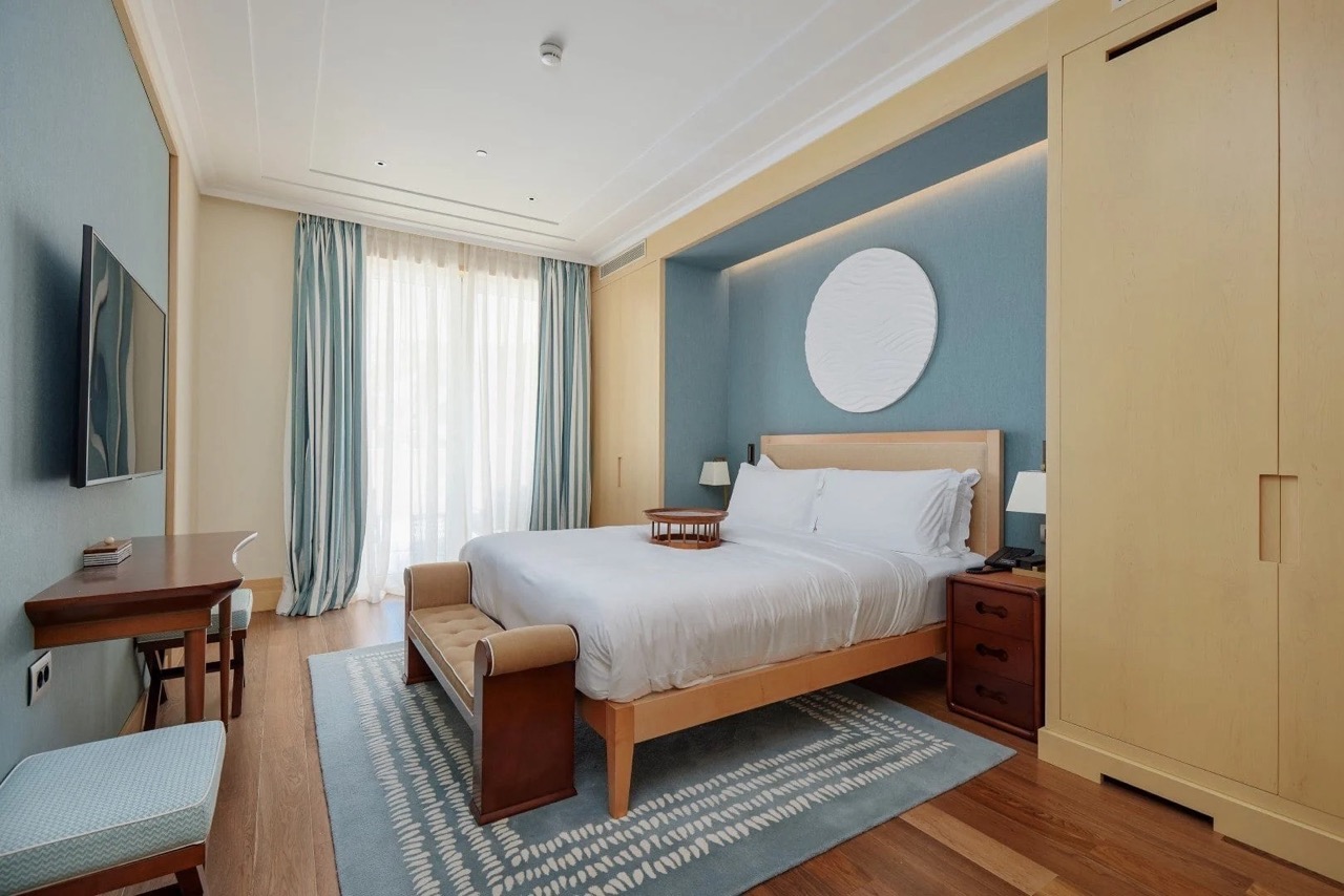 Modern bedroom in an apartment in Porto Montenegro, Tivat, Montenegro: double bed, light furniture and decor.