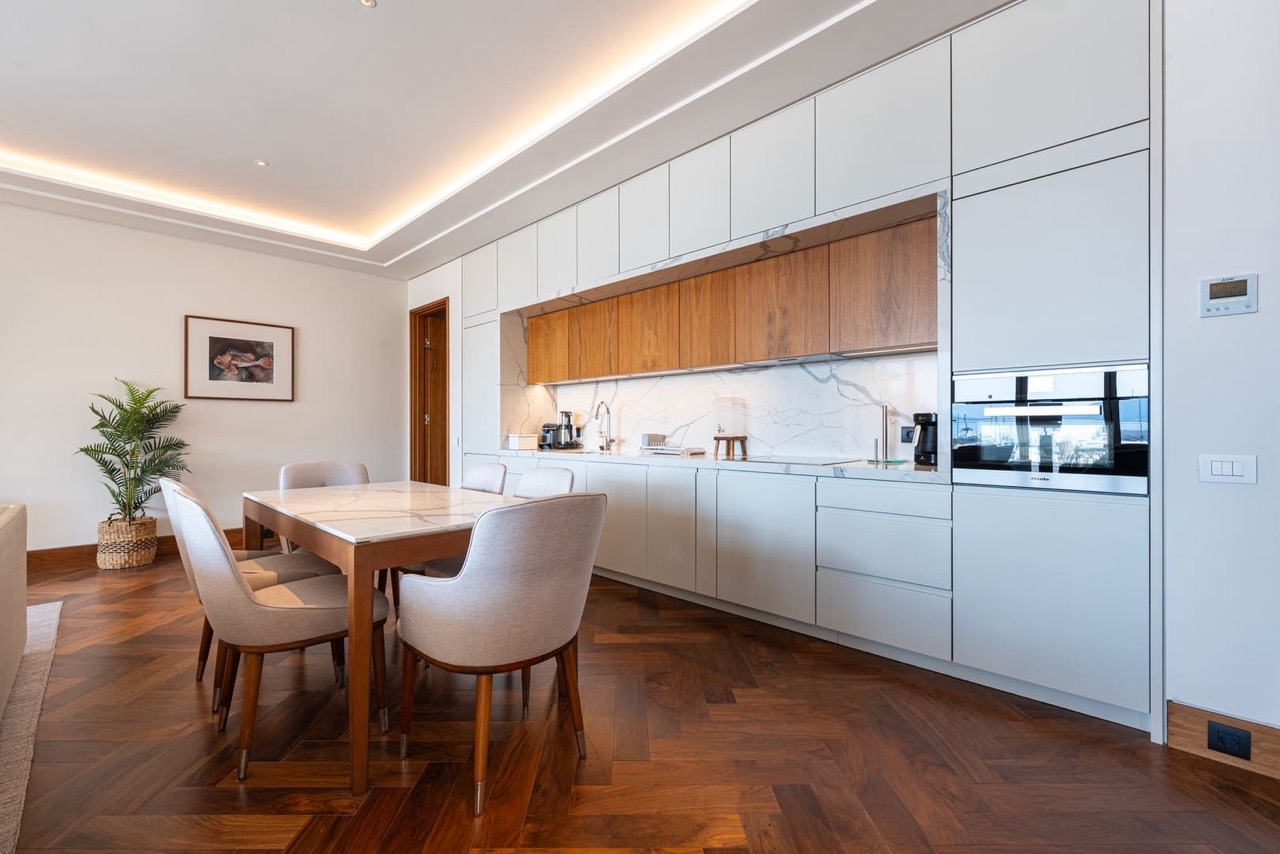 Modern kitchen with marble backsplash and dining area in an apartment in Porto Montenegro, Tivat, Montenegro.