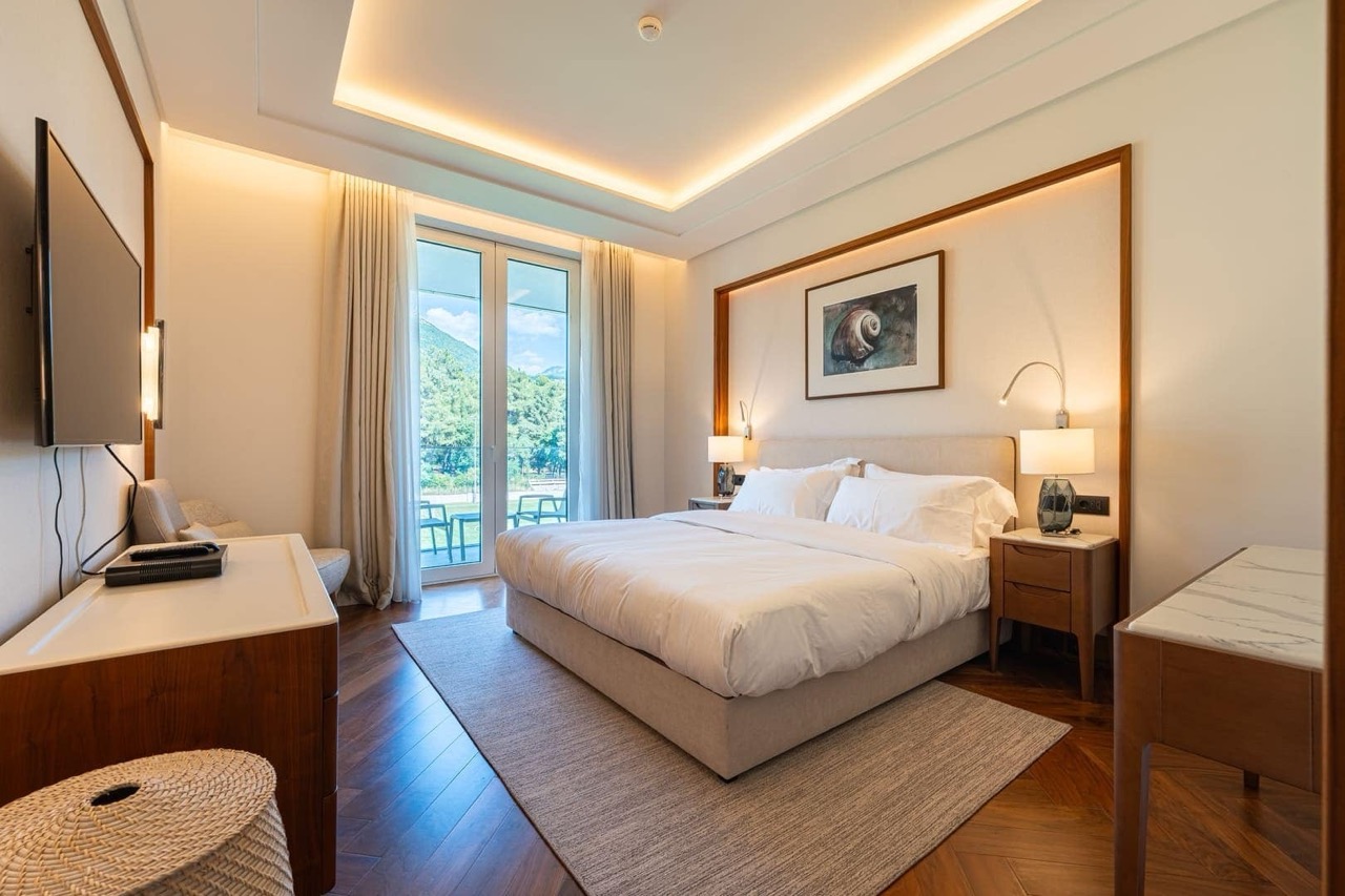 Modern bedroom in an apartment in Porto Montenegro, Tivat, Montenegro: double bed, mountain and terrace view.