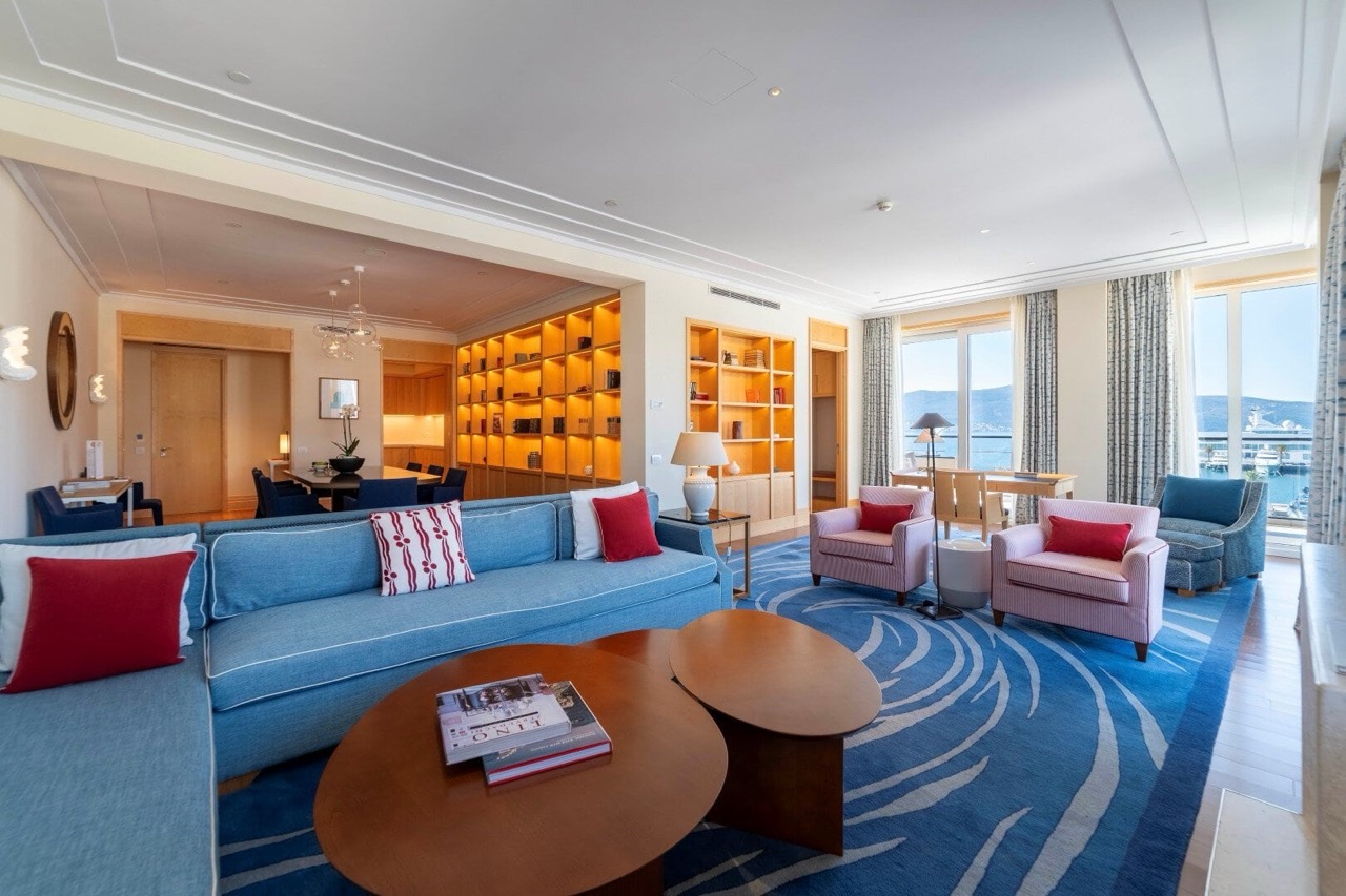 Spacious living room in an apartment in Porto Montenegro, Tivat, Montenegro, with sea view, blue furniture, and shelving.