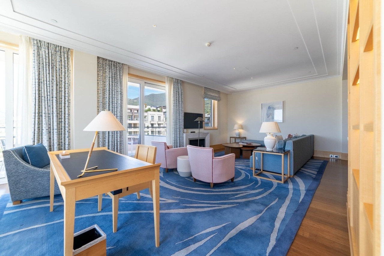 Spacious living room with a blue rug and a workspace in an apartment in Porto Montenegro, Tivat, Montenegro.