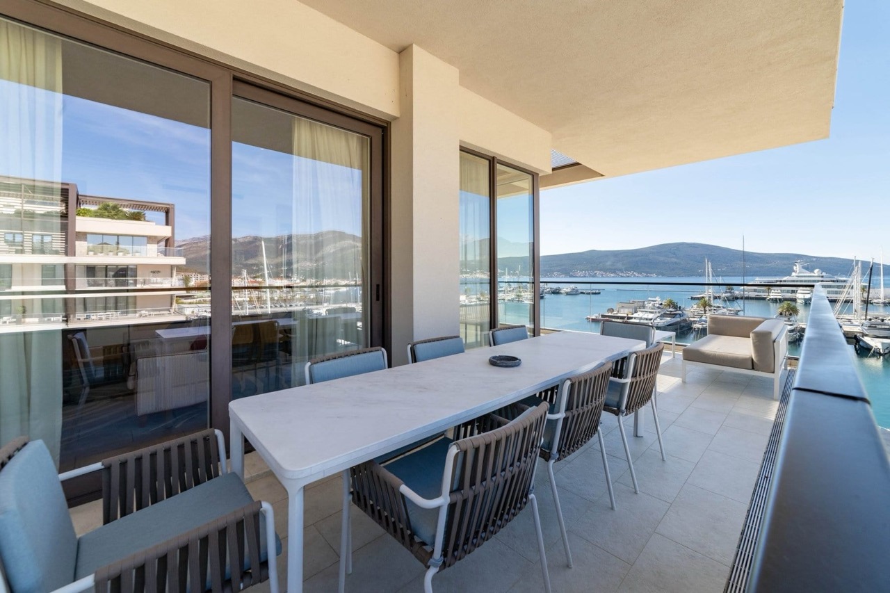 Spacious terrace with a dining area and a view of Porto Montenegro marina, Tivat, Montenegro.