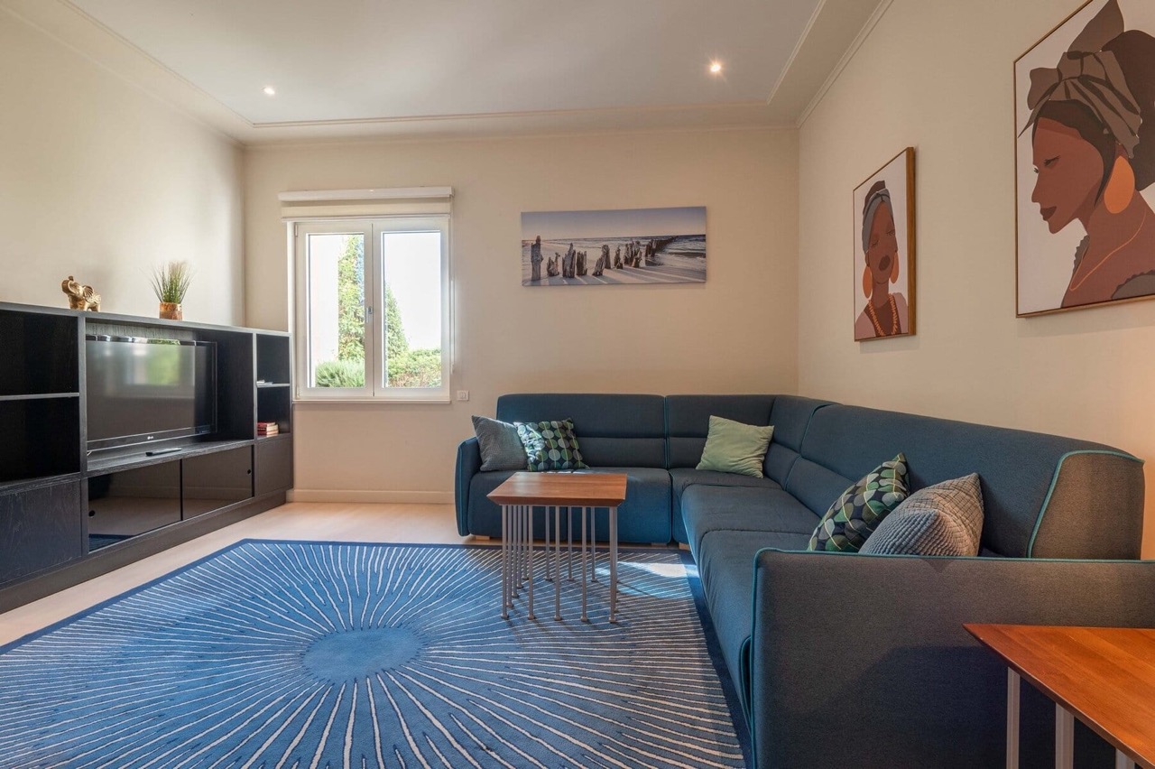 Cozy living room with a blue sofa in an apartment at Porto Montenegro, Tivat, Montenegro: modern interior and TV area.