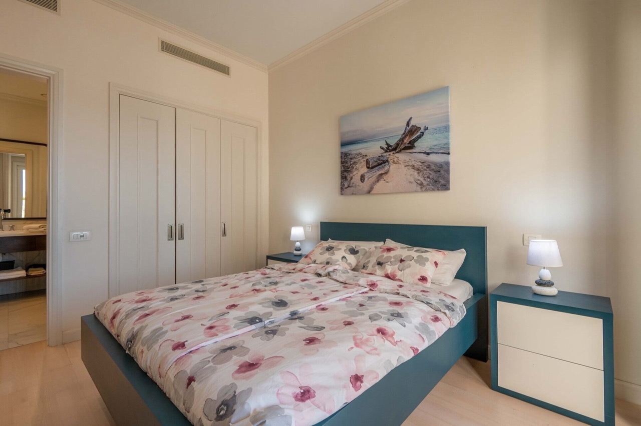 Cozy bedroom with a double bed in an apartment in Porto Montenegro, Tivat, Montenegro: modern interior and wardrobe.