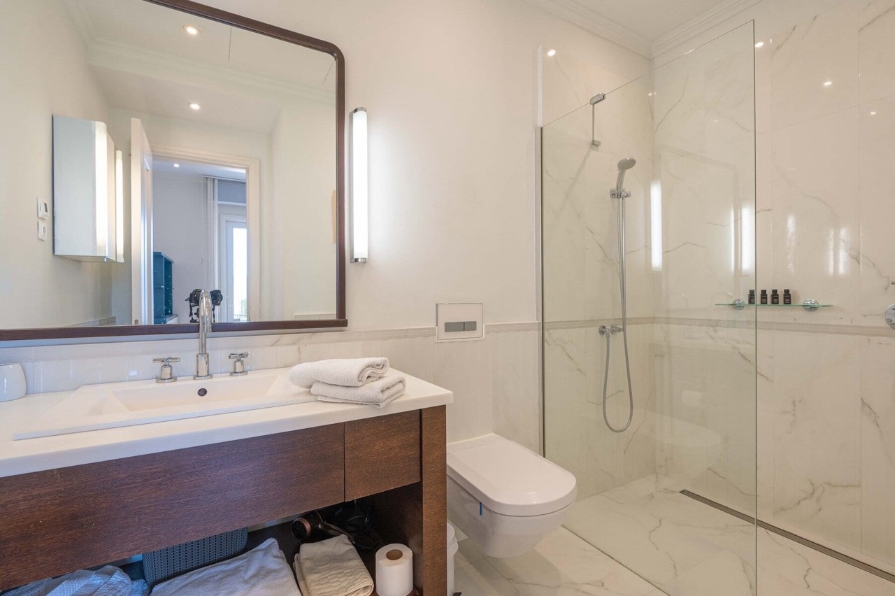 Modern bathroom with a shower cabin and marble-style finishes in an apartment, Porto Montenegro, Tivat, Montenegro.