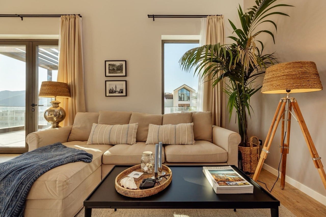 Cozy living room in an apartment in Porto Montenegro, Tivat, Montenegro: beige sofa, stylish decor, and a view of the terrace.