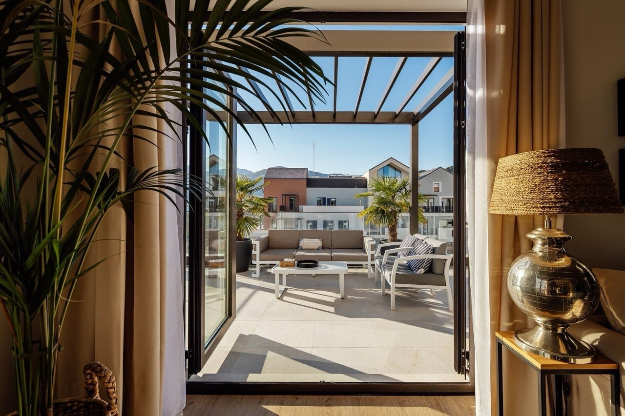 Terrace with furniture and pergola in an apartment in Porto Montenegro, Tivat, Montenegro: city and mountain views from the apartment.