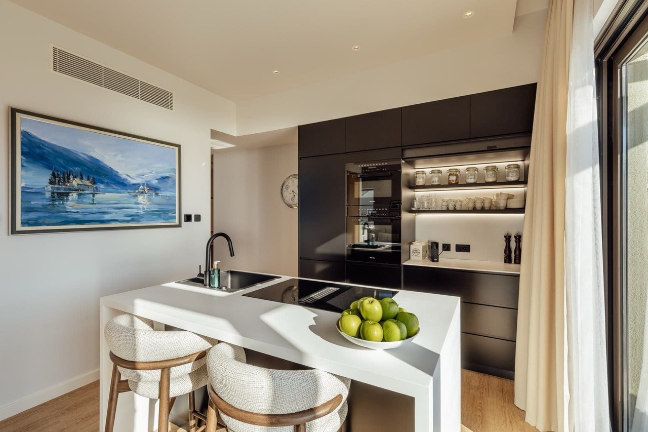Modern kitchen with an island in an apartment in Porto Montenegro, Tivat, Montenegro: stylish interior and built-in appliances.