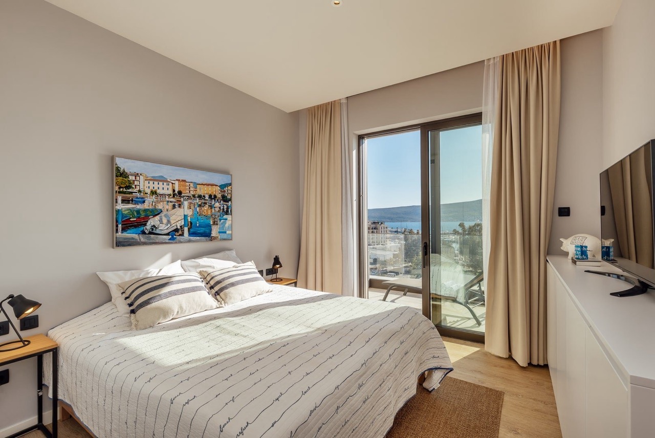 Modern bedroom in Porto Montenegro, Tivat, Montenegro: double bed, sea view, and terrace with balcony.
