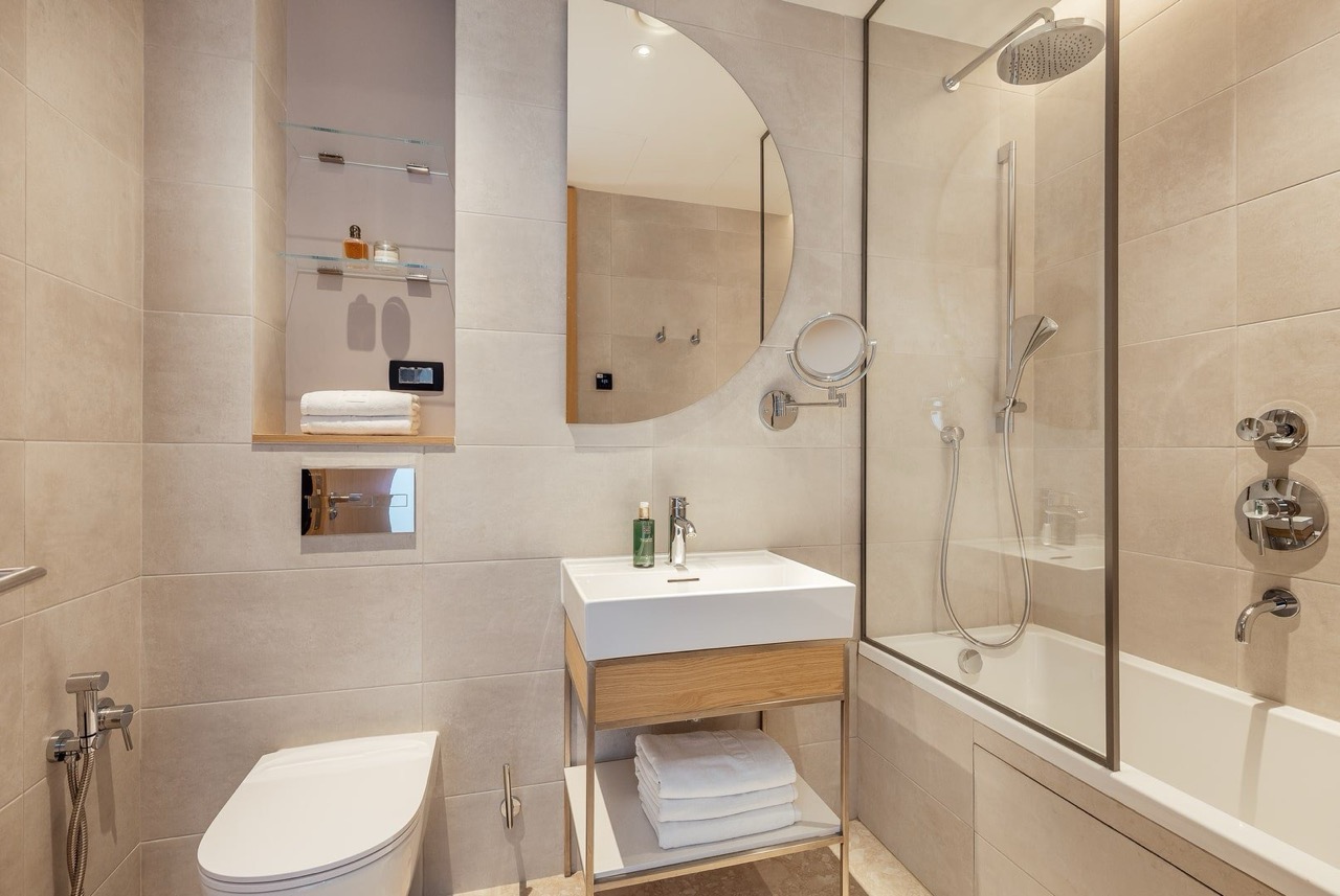 Modern bathroom in an apartment in Porto Montenegro, Tivat, Montenegro: light tiles, shower cabin, and sanitary ware.