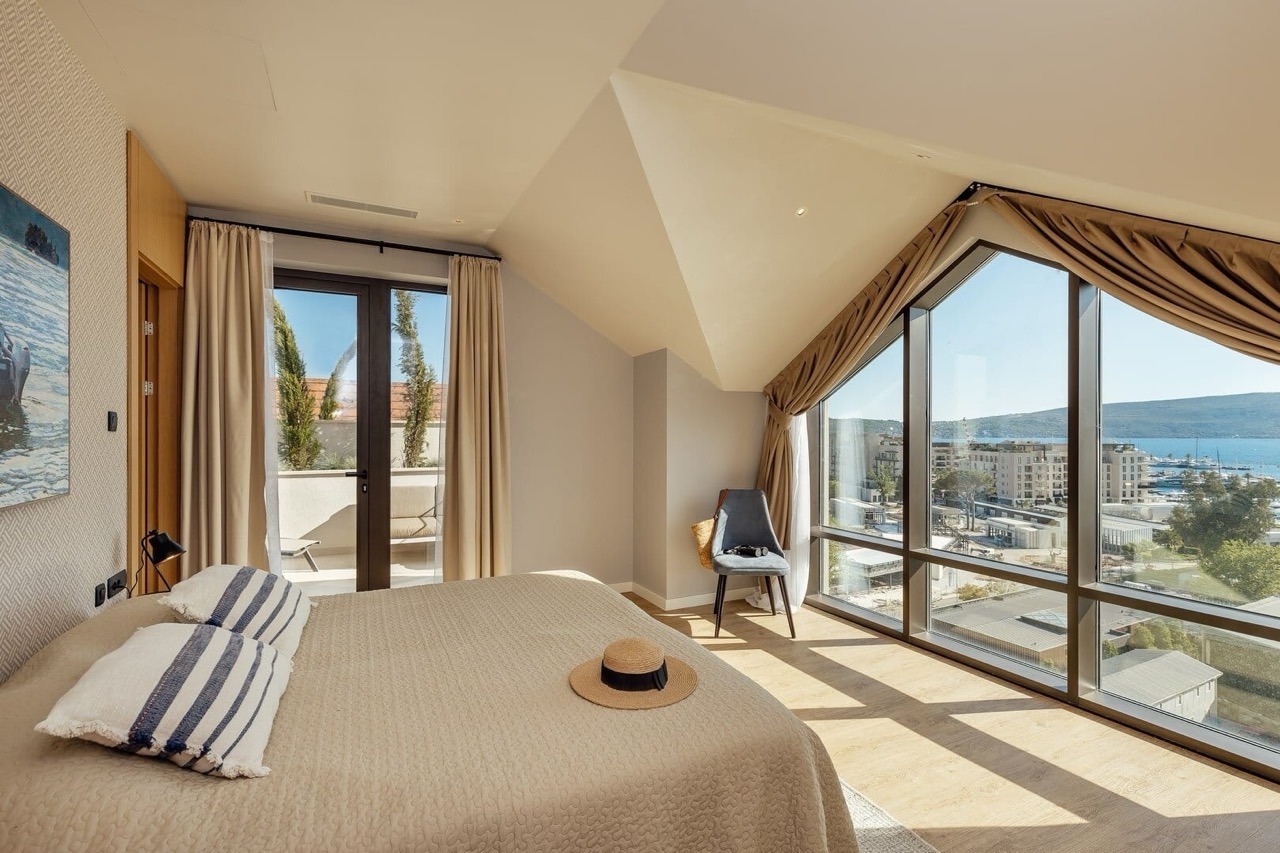 Bedroom in an apartment in Porto Montenegro, Tivat, Montenegro: panoramic windows with sea views, a terrace, and a stylish interior.
