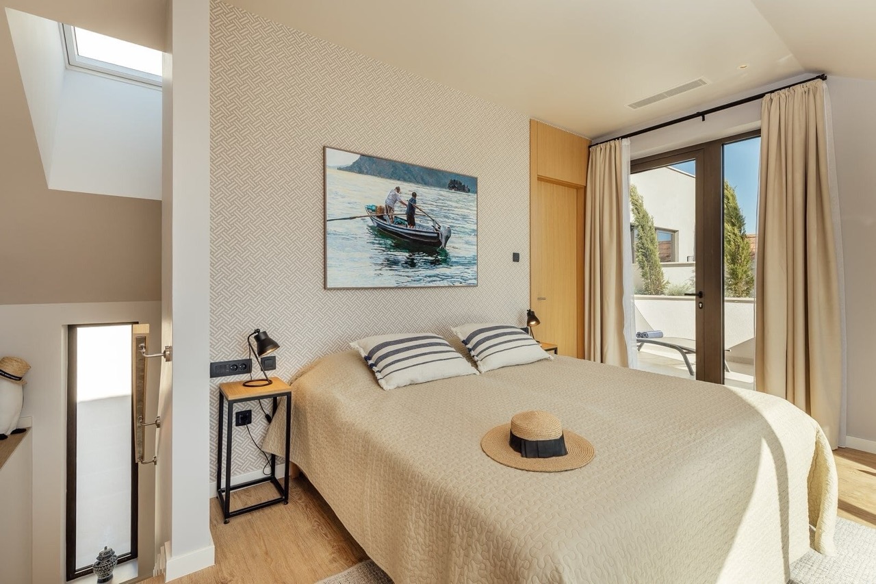 Modern bedroom in an apartment in Porto Montenegro, Tivat, Montenegro: double bed, access to the terrace, and panoramic windows.