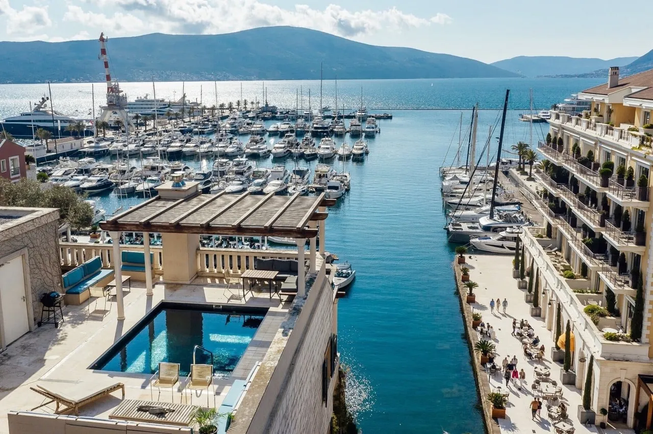 Rooftop pool overlooking a marina filled with boats and the sea.