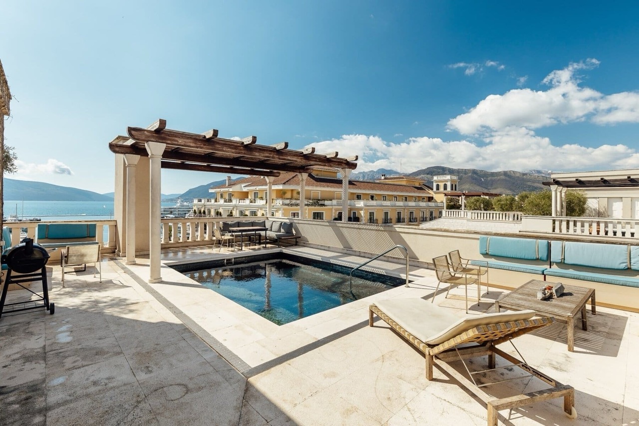 Terrace with a pool and sea view in Porto Montenegro, Tivat, Montenegro: sun loungers, pergola, and lounge area.