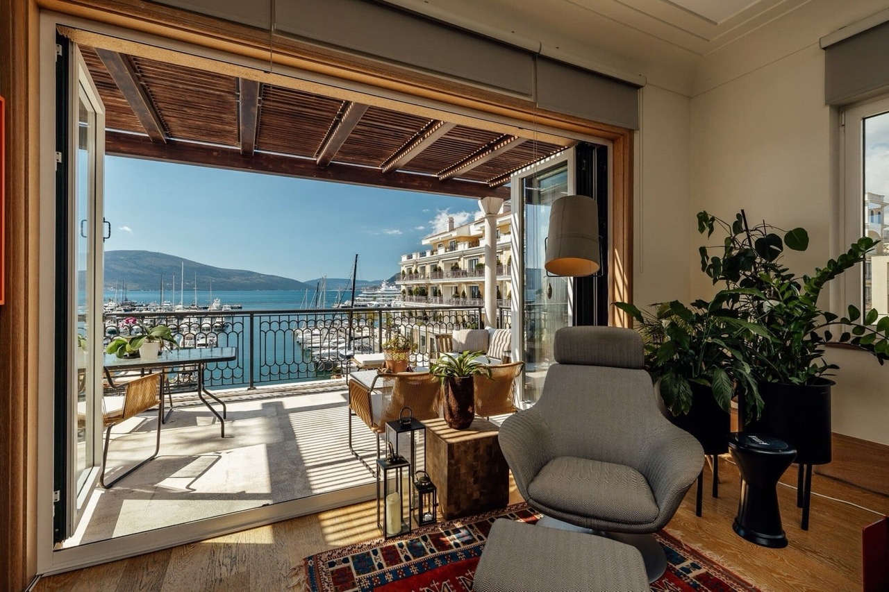 Living room with terrace and marina view in Porto Montenegro, Tivat, Montenegro: modern furniture and panoramic windows.