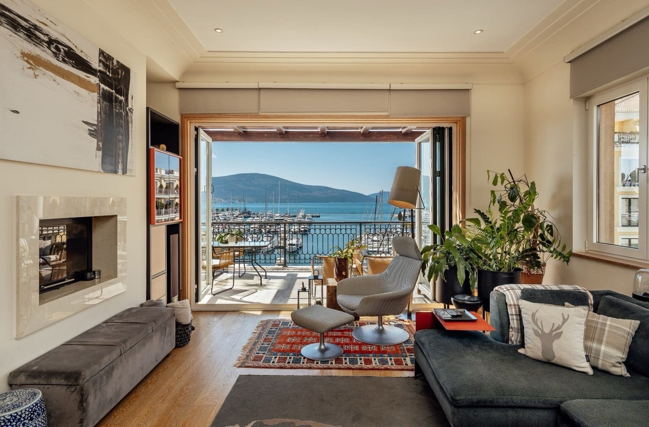 Living room with a fireplace and a view of the marina in Porto Montenegro, Tivat, Montenegro: stylish interior with a terrace.