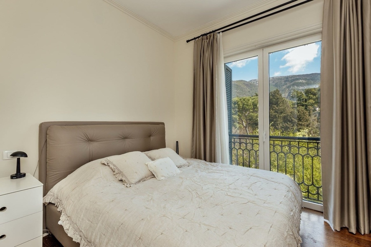Bedroom in an apartment in Porto Montenegro, Tivat, Montenegro: double bed, mountain and greenery view from the balcony.