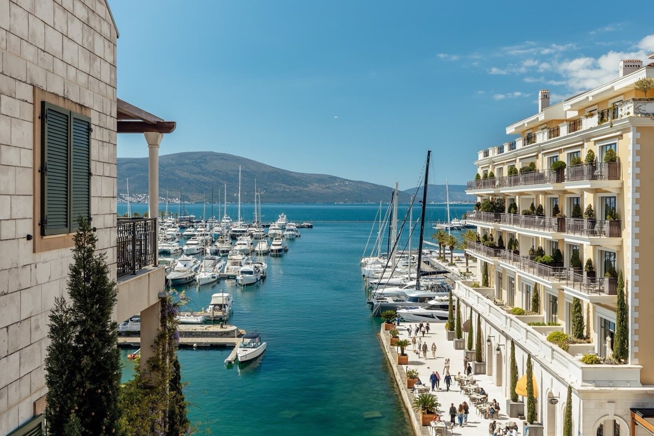 View of the marina with yachts and the Porto Montenegro waterfront in Tivat, Montenegro, from the residential complex terrace.