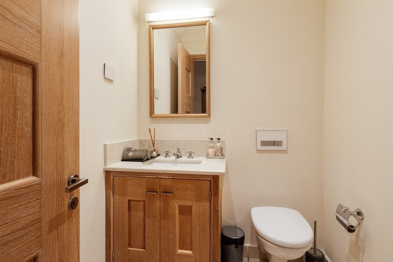 Modern bathroom with a wooden vanity and mirror in an apartment at Porto Montenegro, Tivat, Montenegro.