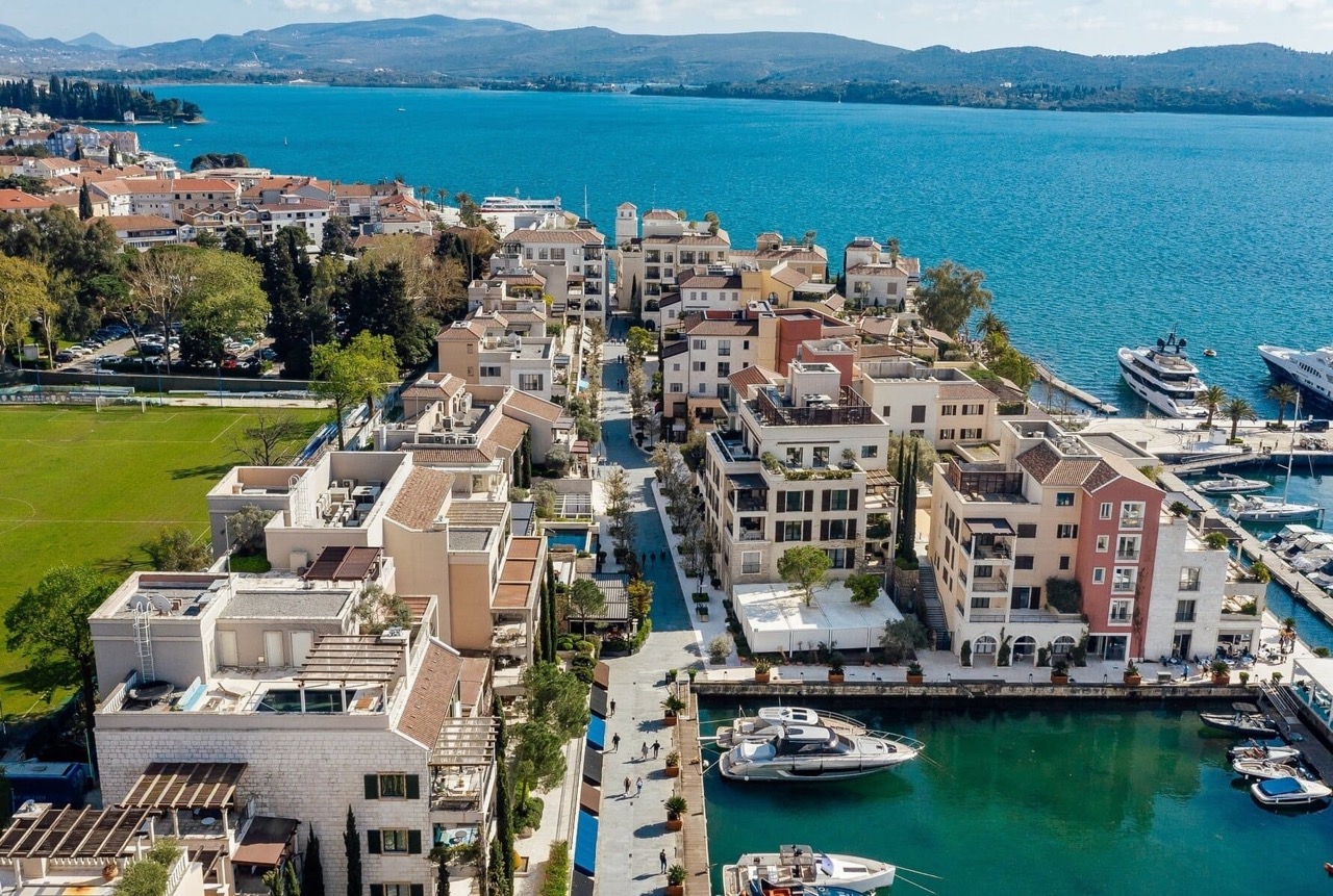 Aerial view of the Porto Montenegro luxury residential complex in Tivat, Montenegro, with a yacht marina and the sea.