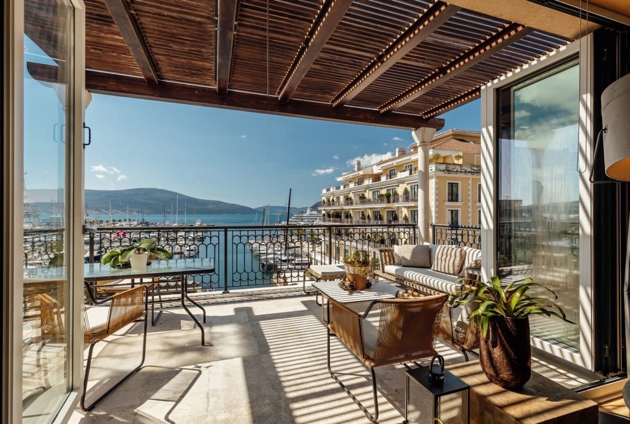 Terrace with furniture and a view of Porto Montenegro Marina, Tivat, Montenegro. Cozy lounge area with a canopy and sea view.