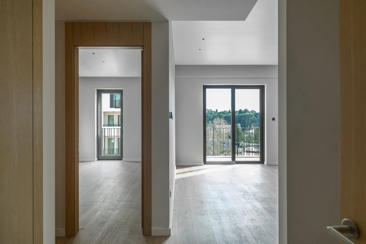 Empty room with light wood flooring and a doorway leading to a hallway or adjacent space.