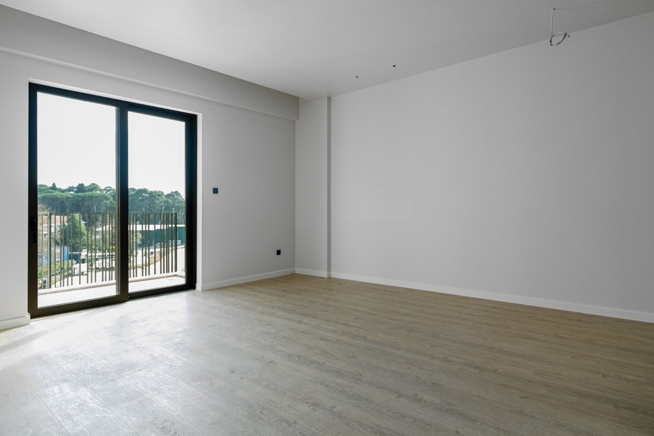 Bright living room with a panoramic window and a view of greenery in an apartment in Porto Montenegro, Tivat, Montenegro.