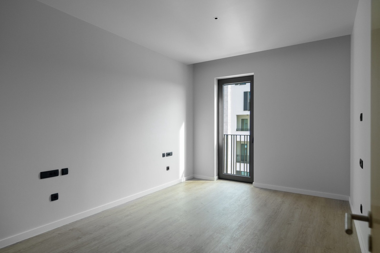 Bright bedroom with laminate flooring and access to the balcony in the Porto Montenegro residential complex, Tivat, Montenegro.