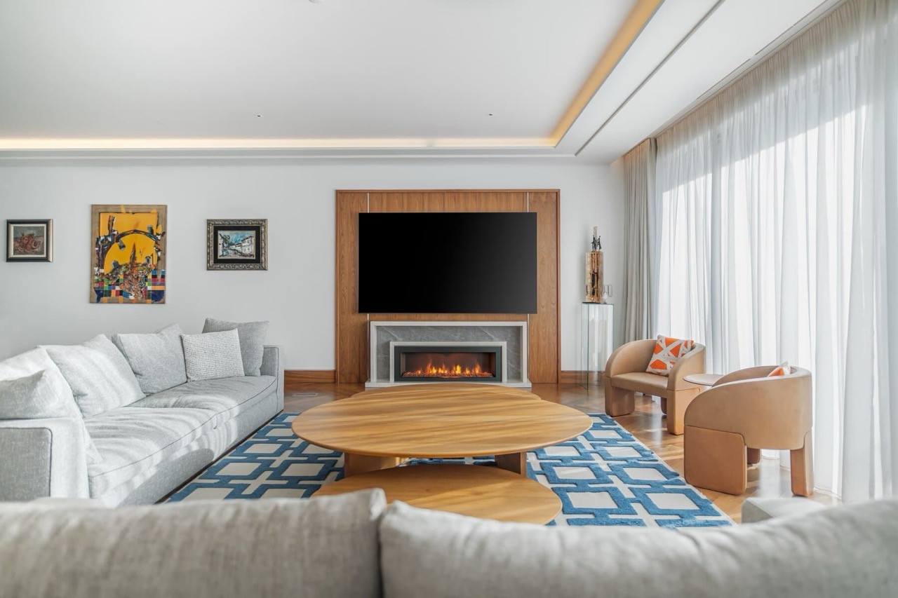 Modern living room in Porto Montenegro, Tivat: fireplace, TV area, designer furniture, and panoramic windows in Montenegro.