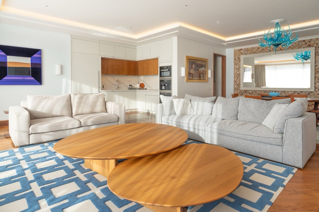 Modern living room with kitchen in an apartment in Porto Montenegro, Tivat, Montenegro: soft seating, wooden tables, and decor.