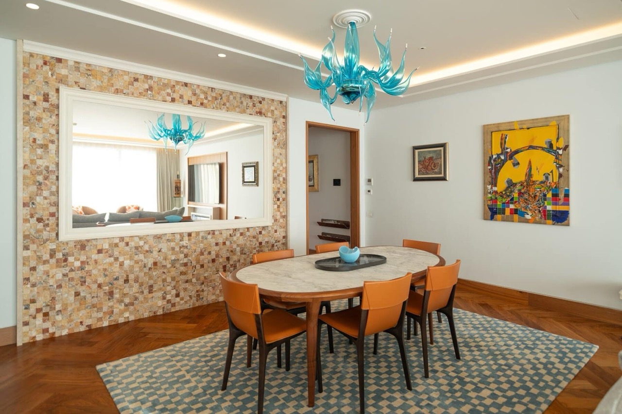 Dining area in an apartment in Porto Montenegro, Tivat: marble table, orange chairs, and decor in a luxury apartment.