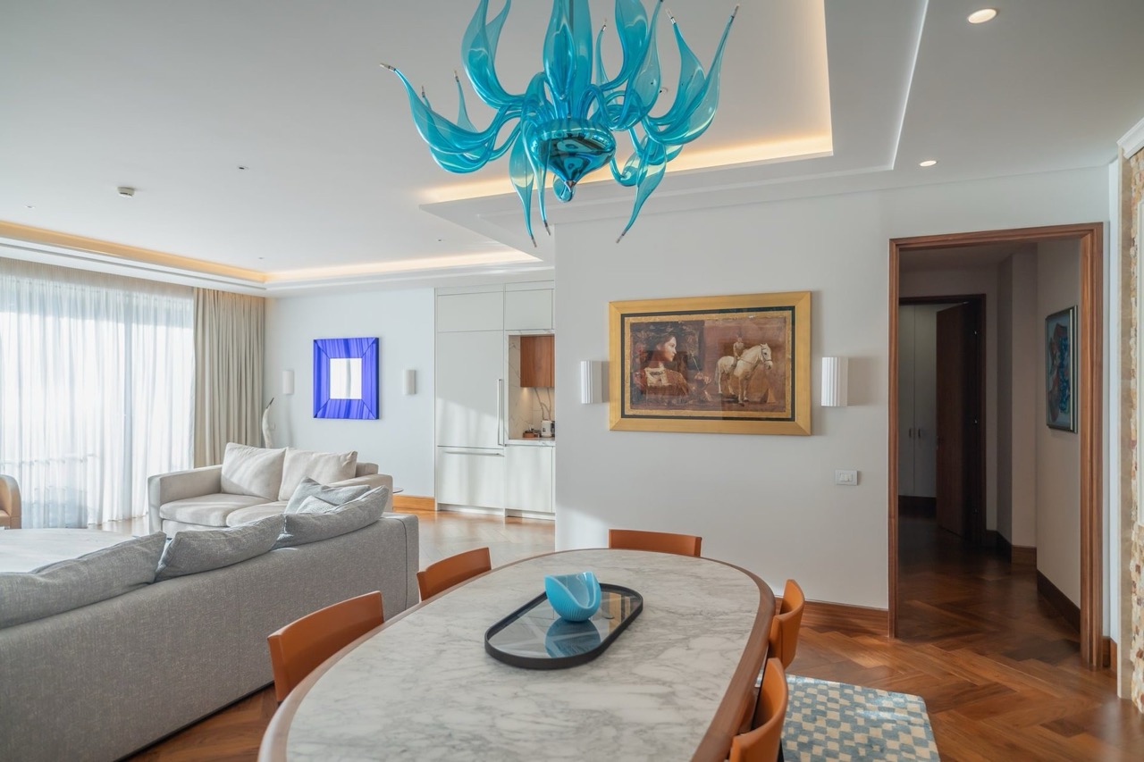 Living room with dining area and designer chandelier in an apartment in the Porto Montenegro luxury residential complex, Tivat, Montenegro.