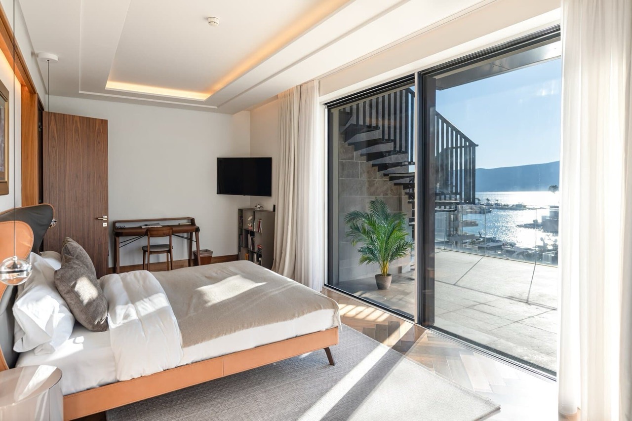 Modern bedroom in Porto Montenegro, Tivat, Montenegro: panoramic sea view, terrace, and stylish furniture.