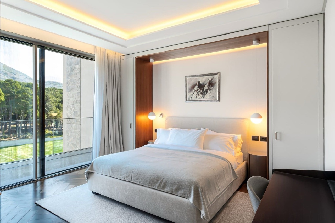 Modern bedroom in Porto Montenegro apartments, Tivat, Montenegro: double bed, panoramic view of the park.