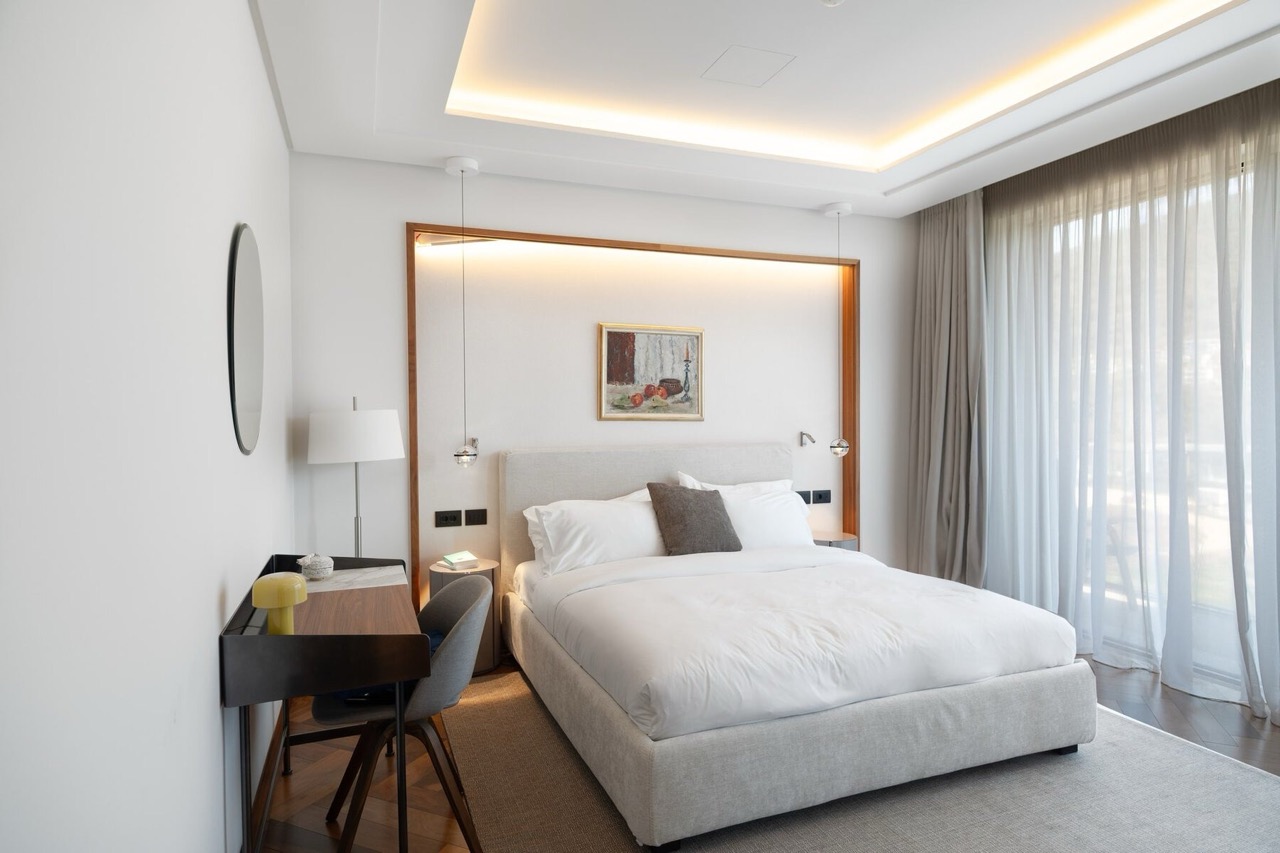 Modern bedroom with a double bed and a desk in Porto Montenegro apartments, Tivat, Montenegro.