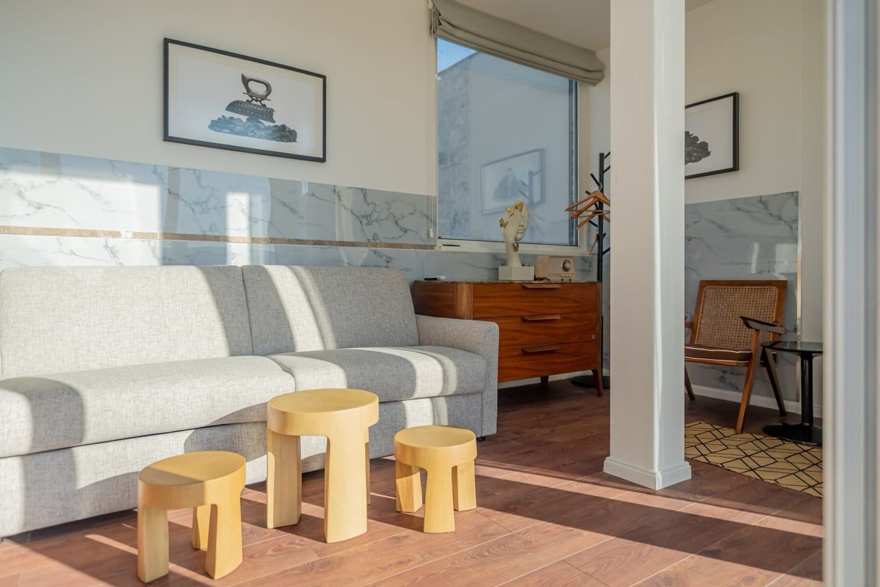 Living room in an apartment in Porto Montenegro, Tivat, Montenegro: gray sofa, wooden tables, and marble wall finishes.