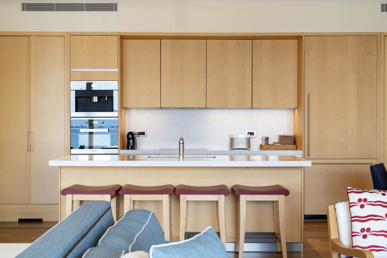 Modern kitchen with wooden fronts and a breakfast bar in an apartment in Tivat, Montenegro. Built-in Miele appliances.