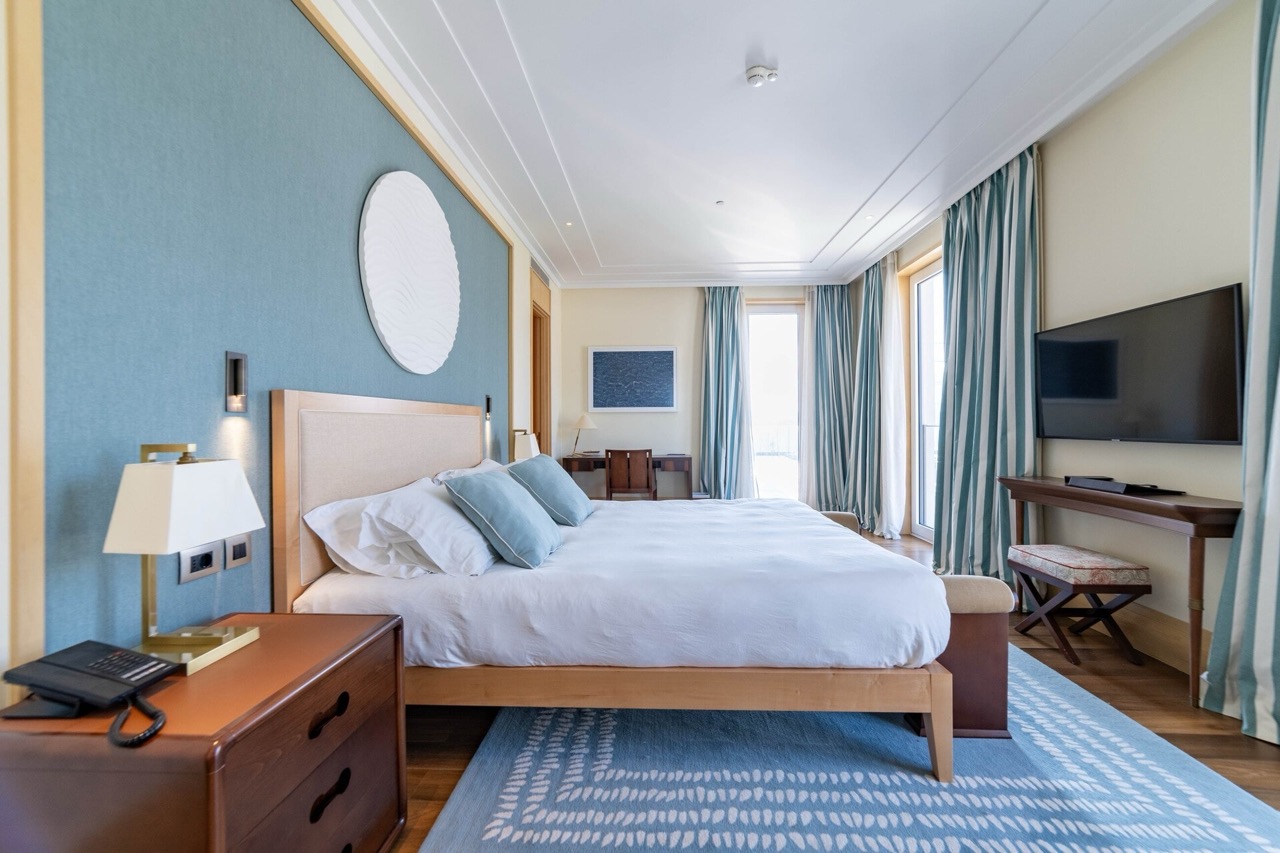 Modern bedroom with a double bed in an apartment in Tivat, Montenegro: stylish interior, view of the terrace.
