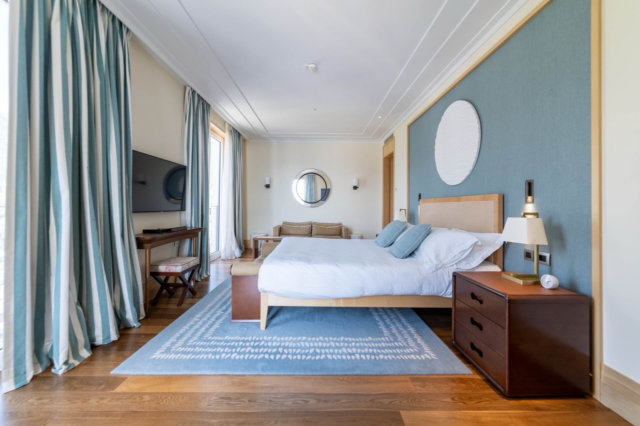 Modern bedroom with a double bed in an apartment in Tivat, Montenegro: stylish interior, parquet flooring, and decor.
