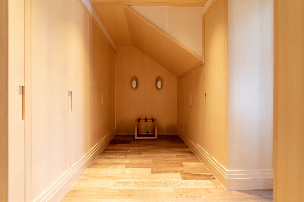 Modern walk-in closet with light wood finishes in an apartment in Tivat, Montenegro. Built-in wardrobes and flooring.