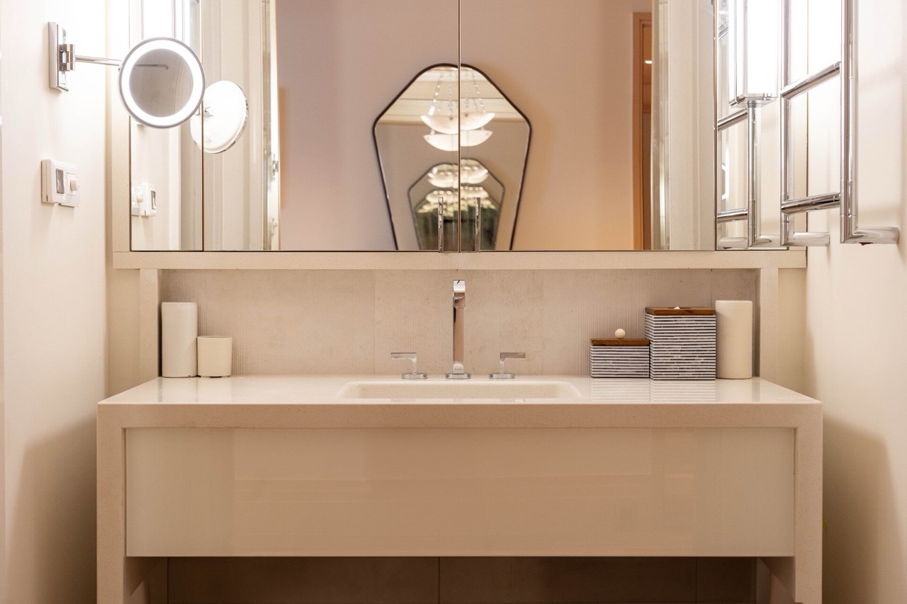 Modern bathroom in an apartment in Tivat, Montenegro: light countertop, built-in sink, and large mirror.