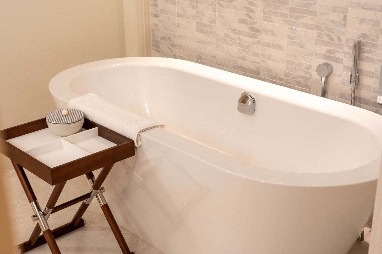 Modern bathroom with a white oval bathtub and tiled finishes in an apartment in Tivat, Montenegro.