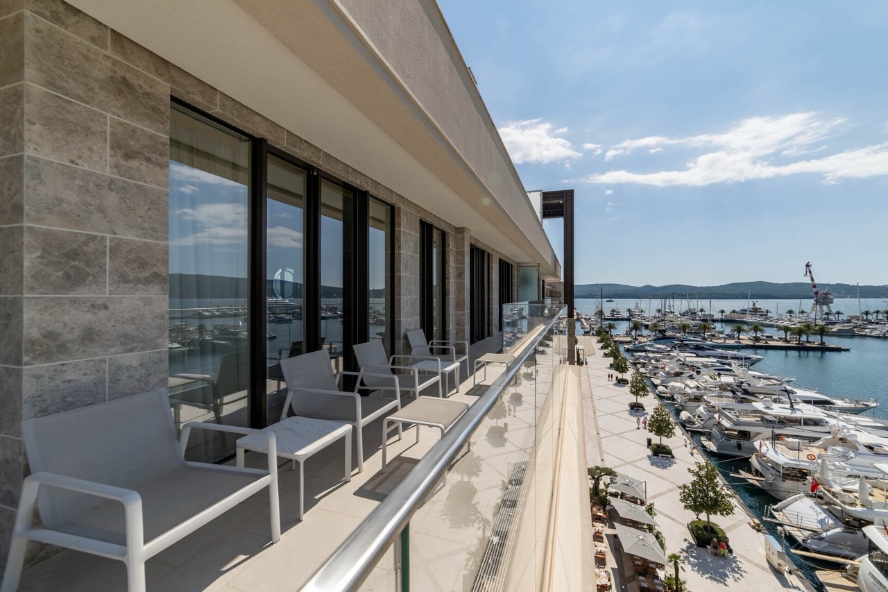 Apartment balcony in Tivat, Montenegro, with modern furniture and panoramic views of the Porto Montenegro luxury yacht marina