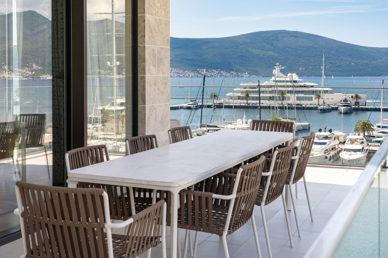 Terrace with a dining area in an apartment in Tivat, Montenegro, with panoramic views of the Porto Montenegro yacht marina.