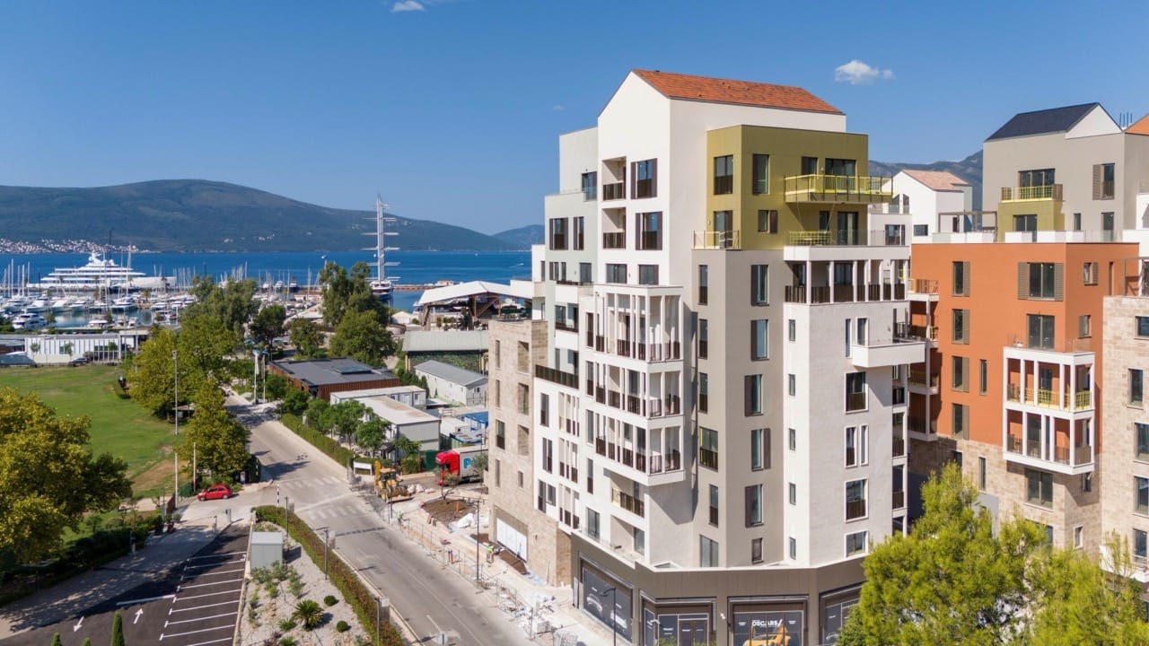 Modern residential complex in Porto Montenegro, Tivat, Montenegro, overlooking the yacht marina and mountains.