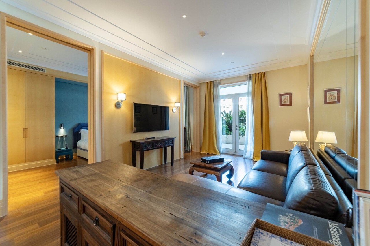 Living room in Porto Montenegro apartments, Tivat, Montenegro: leather sofa, wooden furniture, and access to the terrace.