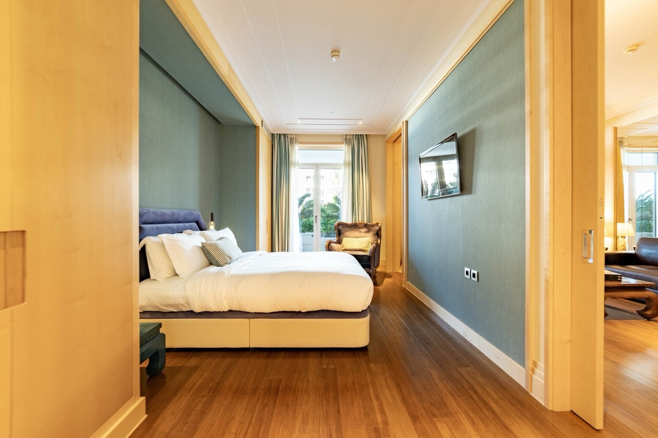 Modern bedroom in Porto Montenegro apartments, Tivat: double bed, wooden floor, and view of the terrace.