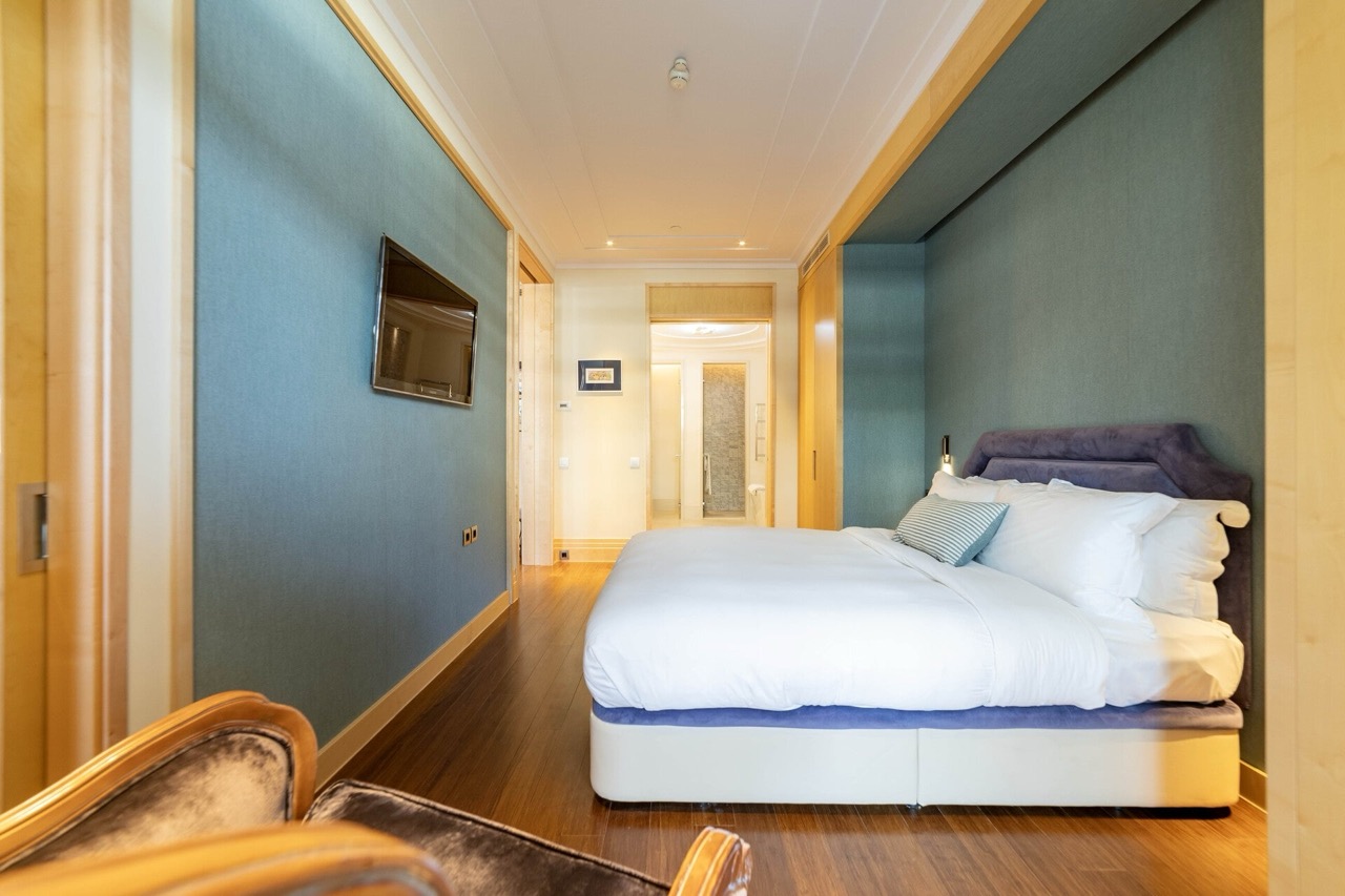 Modern bedroom with a double bed in an apartment in Porto Montenegro, Tivat, Montenegro. Interior with blue walls.