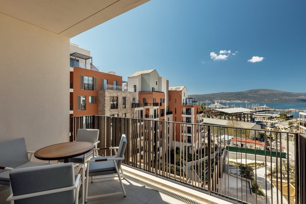 Balcony with furniture in the premium Porto Montenegro residential complex, Tivat, Montenegro, overlooking the marina and mountains.